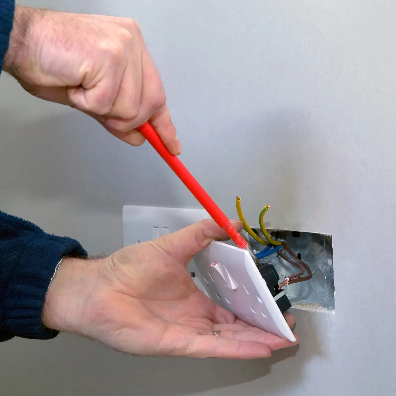 electrician fixing a plug socket