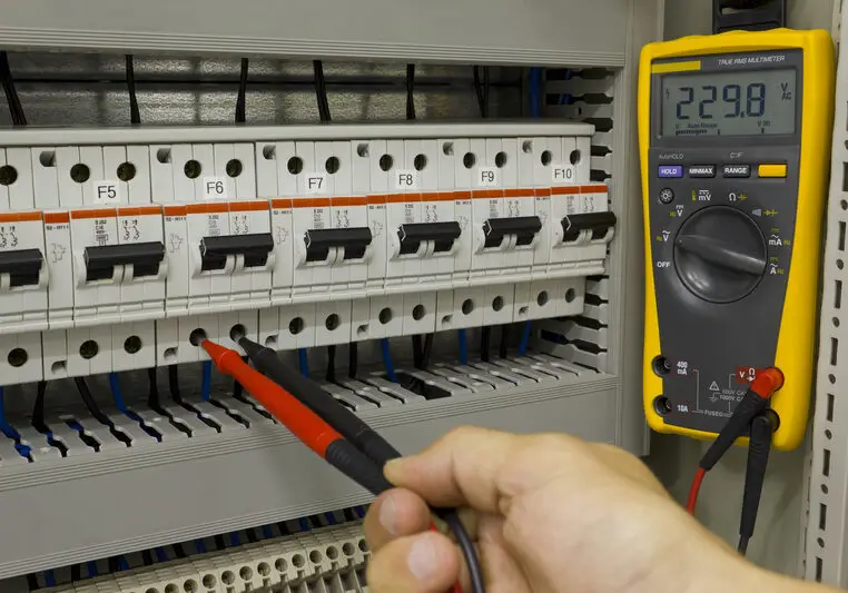 Electrical engineer at work. Electrical engineer measuring voltage on a miniature circuit breaker.